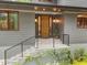 Contemporary home featuring a welcoming entrance with a modern black railing and attractive landscaping at 1115 Trailwood Dr, Raleigh, NC 27606