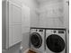Well-organized laundry room featuring modern washer and dryer with overhead storage shelves at 1115 Trailwood Dr, Raleigh, NC 27606
