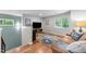 Cozy living room space with hardwood floors, neutral walls, and large windows overlooking greenery at 1115 Trailwood Dr, Raleigh, NC 27606