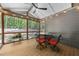 Relaxing screened porch with a dining table, chairs, and scenic views of the surrounding woods at 1115 Trailwood Dr, Raleigh, NC 27606