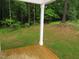Covered back porch with wood floors offering scenic views of the wooded backyard at 119 Oak Ridge Rd, Franklinton, NC 27525