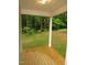 Covered back porch with wood floors offering scenic views of the wooded backyard at 119 Oak Ridge Rd, Franklinton, NC 27525