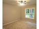 Neutral bedroom featuring carpet, ceiling fan, and natural light from a window with wooded views at 119 Oak Ridge Rd, Franklinton, NC 27525