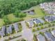 Aerial view of a neighborhood with a pond surrounded by trees and greenery at 1205 Quincy Cottage Rd, Hillsborough, NC 27278