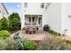 Backyard patio with dining and outdoor kitchen, plus lush garden and covered porch at 1205 Quincy Cottage Rd, Hillsborough, NC 27278