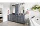 Bathroom featuring a double vanity with stone countertops and a soaking tub at 1205 Quincy Cottage Rd, Hillsborough, NC 27278