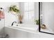 Bright bathroom featuring a soaking tub with a modern black faucet and neutral decor at 1205 Quincy Cottage Rd, Hillsborough, NC 27278