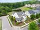 Aerial view of a white two-story home with landscaped yard and a tranquil pond at 1205 Quincy Cottage Rd, Hillsborough, NC 27278