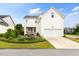 Exterior view of a white two-story home with landscaped front yard and a two-car garage at 1205 Quincy Cottage Rd, Hillsborough, NC 27278