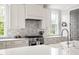 Bright kitchen featuring stone backsplash, modern appliances, and stone countertops at 1205 Quincy Cottage Rd, Hillsborough, NC 27278