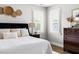 Close-up of a bedroom featuring a bed with throw pillows and a side table with a lamp at 1205 Quincy Cottage Rd, Hillsborough, NC 27278
