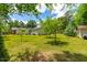 Manicured backyard with lush green lawn and mature trees, perfect for outdoor activities at 1209 Maple Ave, Apex, NC 27502