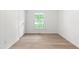Bright bedroom featuring a window with natural light and wood grain flooring at 1209 Maple Ave, Apex, NC 27502