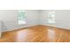 Bright bedroom featuring hardwood floors, large windows, and traditional trim throughout at 1209 Maple Ave, Apex, NC 27502