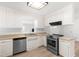 Bright kitchen with stainless steel appliances, white cabinetry, and modern fixtures providing a clean aesthetic at 1209 Maple Ave, Apex, NC 27502
