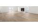 Bright living room with a fireplace, beautiful flooring, and access to the outdoors through french doors at 1209 Maple Ave, Apex, NC 27502