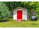 Backyard shed with a vibrant red door, offering ample storage and character at 1209 Maple Ave, Apex, NC 27502