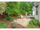 Inviting backyard featuring a cozy deck, lush greenery, stone patio and a grill, perfect for outdoor relaxation at 123 Chimney Rise Dr, Cary, NC 27511