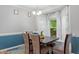 Stylish dining area showcasing an elegant light fixture, comfortable seating, and a view of the garden at 123 Chimney Rise Dr, Cary, NC 27511