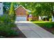Charming brick home with a white garage door, colorful landscaping, and a long driveway at 123 Chimney Rise Dr, Cary, NC 27511