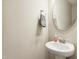 Clean and contemporary powder room with a pedestal sink, round mirror, and modern fixtures at 127 Manordale Dr, Chapel Hill, NC 27517