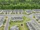 Aerial view of townhomes with manicured lawns, sidewalks, and mature trees and landscaping at 1310 Compass Dr, Durham, NC 27713