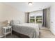 Bright bedroom featuring a large window with natural light, a side table and neutral tones at 1310 Compass Dr, Durham, NC 27713