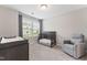 Bedroom room with a crib, changing table, gray glider chair and a window bringing in natural light at 1310 Compass Dr, Durham, NC 27713