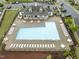 Aerial view of the community pool featuring seating, meticulous landscaping, and a clubhouse at 1310 Compass Dr, Durham, NC 27713
