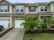 Exterior view of townhome featuring stone accents, neutral siding, and attached garages at 1310 Compass Dr, Durham, NC 27713