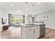 Open-concept kitchen with island, granite countertops, stainless steel appliances, and view to the living room at 1310 Compass Dr, Durham, NC 27713