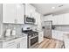 Modern kitchen with stainless steel appliances, granite countertops, and white cabinetry at 1310 Compass Dr, Durham, NC 27713