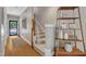 Inviting foyer with hardwood floors, a carpeted staircase, and decorative shelving unit, offering a warm welcome at 137 Lanigan Pl, Cary, NC 27513