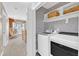 Laundry room featuring modern appliances, stylish wallpaper, and upper shelving at 137 Lanigan Pl, Cary, NC 27513