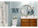 Charming bathroom with a round mirror, stylish fixtures, and soft blue walls creating a tranquil space at 1520 Palmer Hill Dr, Durham, NC 27703