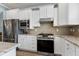 Well-equipped kitchen featuring stainless steel appliances, granite countertops, and white cabinetry at 1520 Palmer Hill Dr, Durham, NC 27703