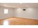 Spacious, well-lit finished basement with laminate wood flooring and wall-mounted television bracket at 1536 Granville Street, Burlington, NC 27215