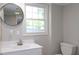 Bathroom showcasing a white vanity and commode, complemented by a bright window at 1536 Granville Street, Burlington, NC 27215