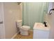 This bathroom includes a toilet, a shower with a curtain, and a vanity sink with a cabinet at 1536 Granville Street, Burlington, NC 27215