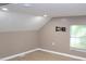 Bedroom featuring a slanted ceiling, light walls and floors, and a window with natural light at 1536 Granville Street, Burlington, NC 27215