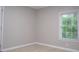 Bright bedroom with neutral walls, light-colored floors, white trim, and a window showcasing green foliage at 1536 Granville Street, Burlington, NC 27215