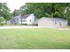Lawn view of multiple homes, including one with vinyl siding and a detached outbuilding at 1536 Granville Street, Burlington, NC 27215