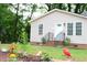 Landscaped front yard with brick stairs, flower garden, and small green bushes leading to beige house at 1536 Granville Street, Burlington, NC 27215