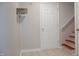 Neutral hallway featuring a white door, open shelf with brackets, and a staircase with wood steps at 1536 Granville Street, Burlington, NC 27215