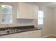 This kitchen features dual stainless steel sink, white cabinets, with a view from the windows at 1536 Granville Street, Burlington, NC 27215