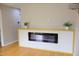 Blonde floors in living room with electric fireplace, and floating shelf with two ferns on top at 1536 Granville Street, Burlington, NC 27215
