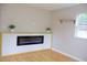 Bright living room with blonde floors and an electric fireplace beneath a floating shelf at 1536 Granville Street, Burlington, NC 27215