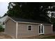 Exterior of a new outbuilding with double doors and a window set against a lush green landscape at 1536 Granville Street, Burlington, NC 27215