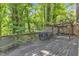 Back deck with table and grill and green foliage at 1702 Falls Church Rd, Raleigh, NC 27609