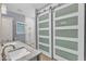 Bathroom with double sink vanity, walk-in shower, and a sliding barn door for the closet at 1702 Falls Church Rd, Raleigh, NC 27609